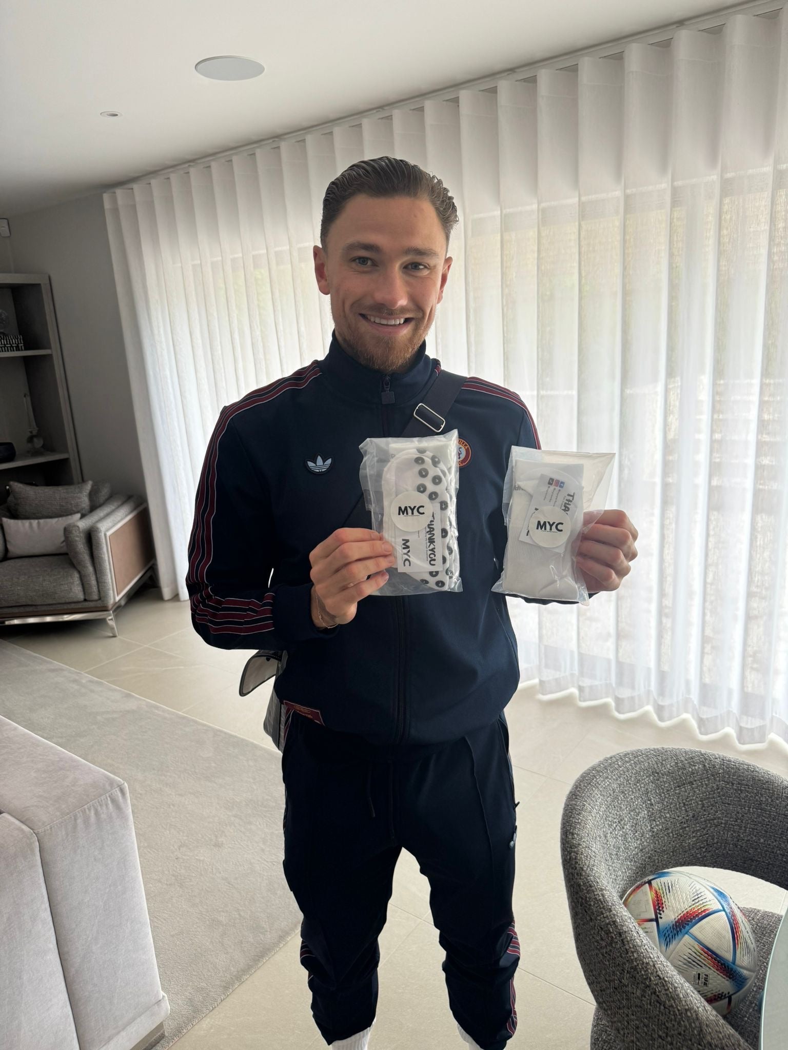 Footballer holding two packs of MYC Performance socks